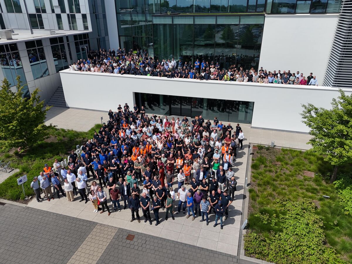 Employee group photo in front of Reynaers Campus.