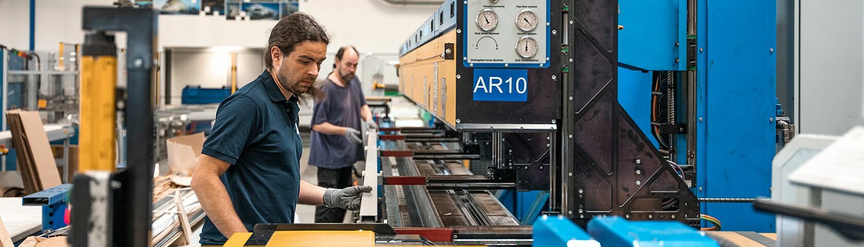 Two Reynaers Aluminium employees working at the insulation assembly line.